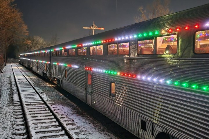 Train with colorful lights on snowy tracks at night.