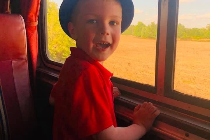 a little boy standing in front of a window