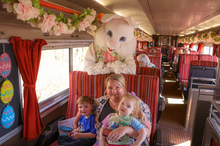 Family posing with Easter Bunny on a decorated train.